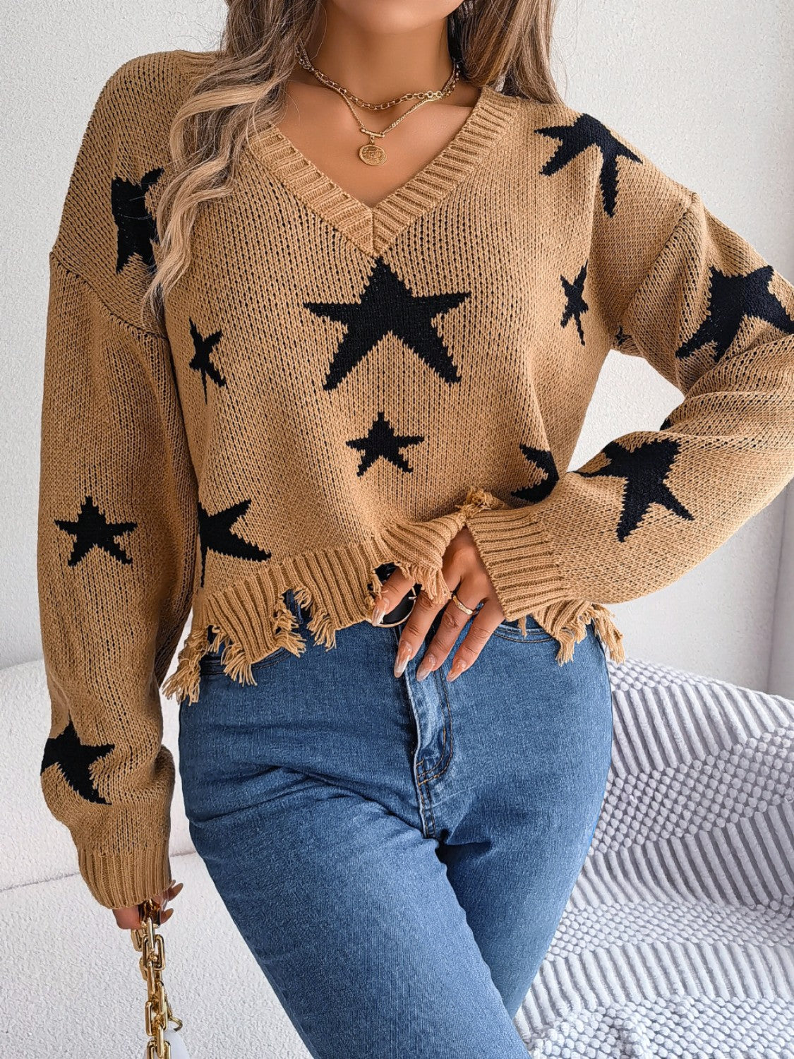 Camel knit sweater with black stars, V-neck, distressed hem, long sleeves
