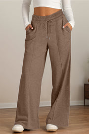 Seamed palazzo lounge trousers in taupe with drawstring waist and pockets.