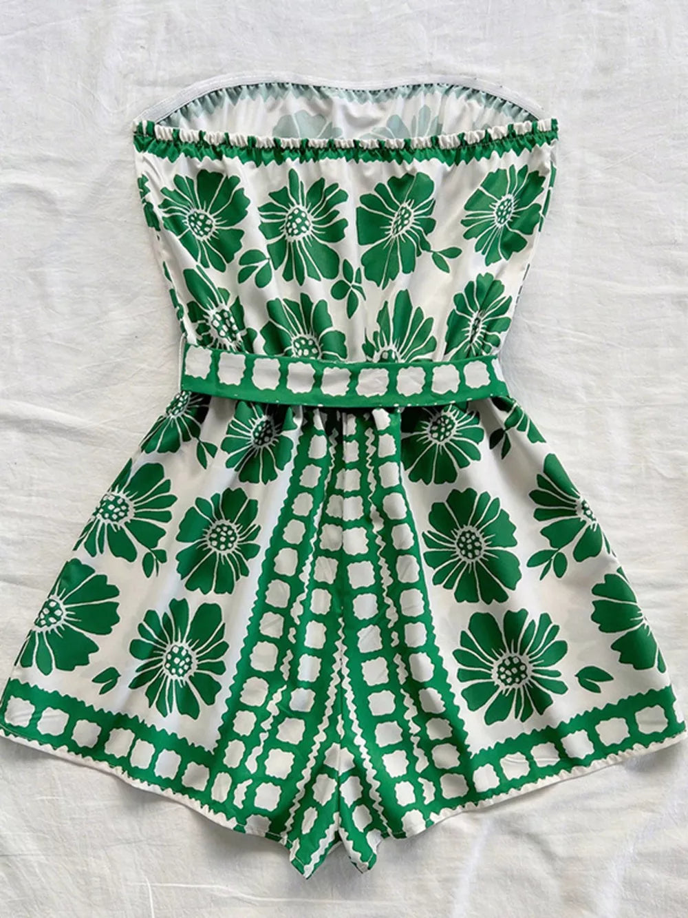 Green floral tie-waist strapless romper with a ruffled hem and playful geometric print.