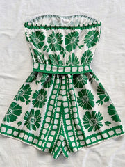 Green floral tie-waist strapless romper with a ruffled hem and playful geometric print.