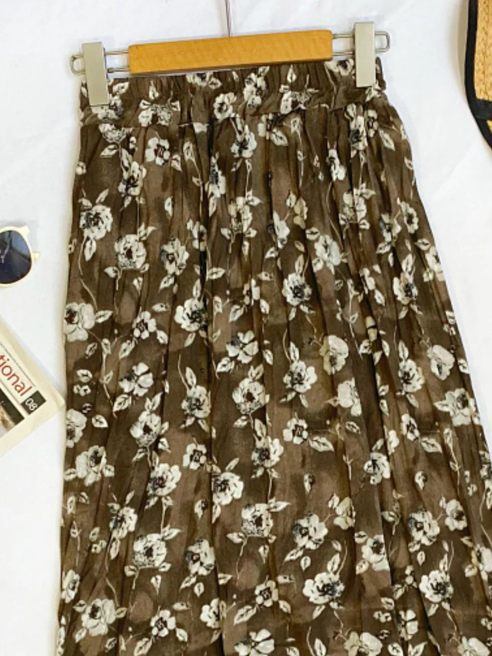Botanical pleated midi skirt in tan with a crinkled texture and floral print.