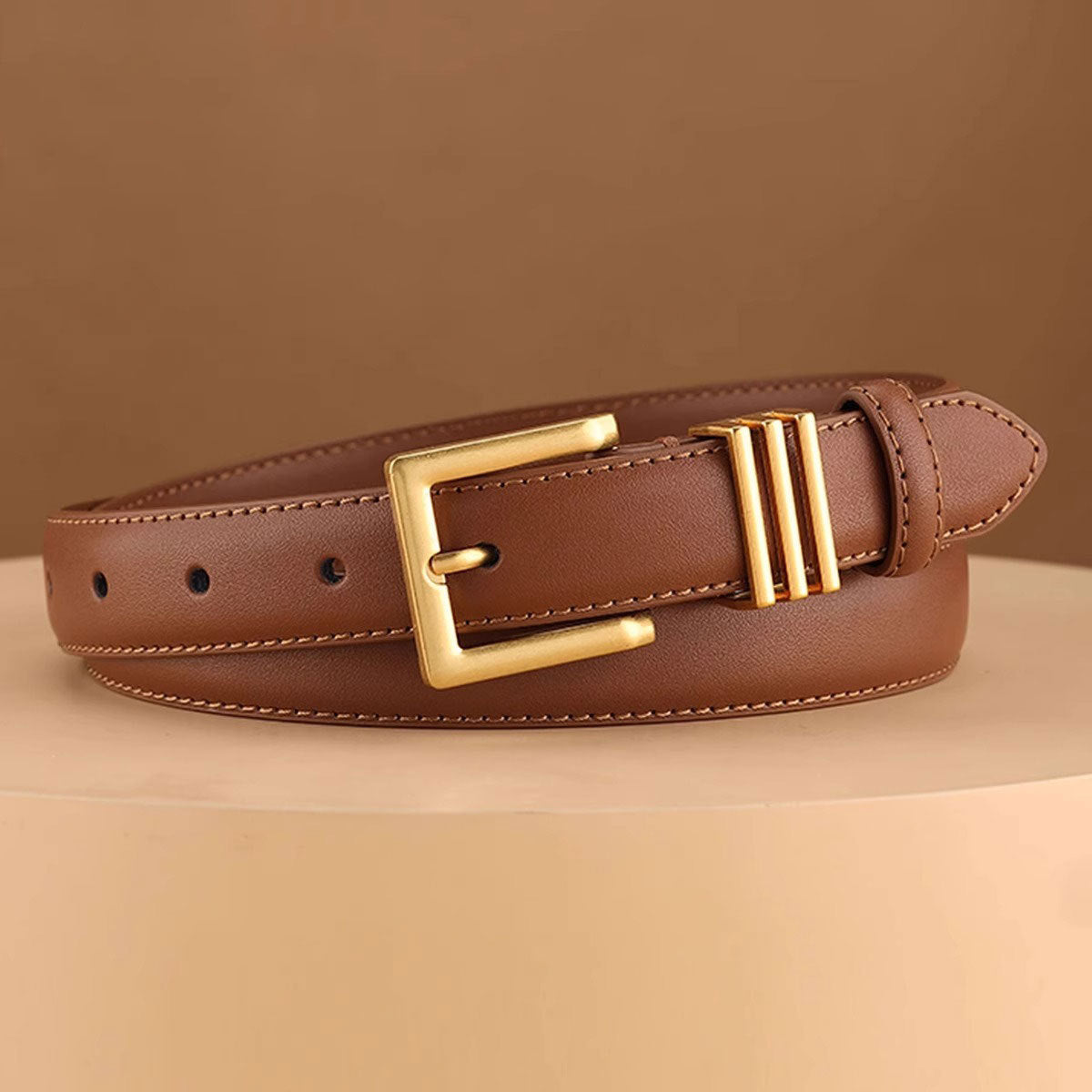 Brown cowhide leather belt with adjustable fit and golden buckle detail.
