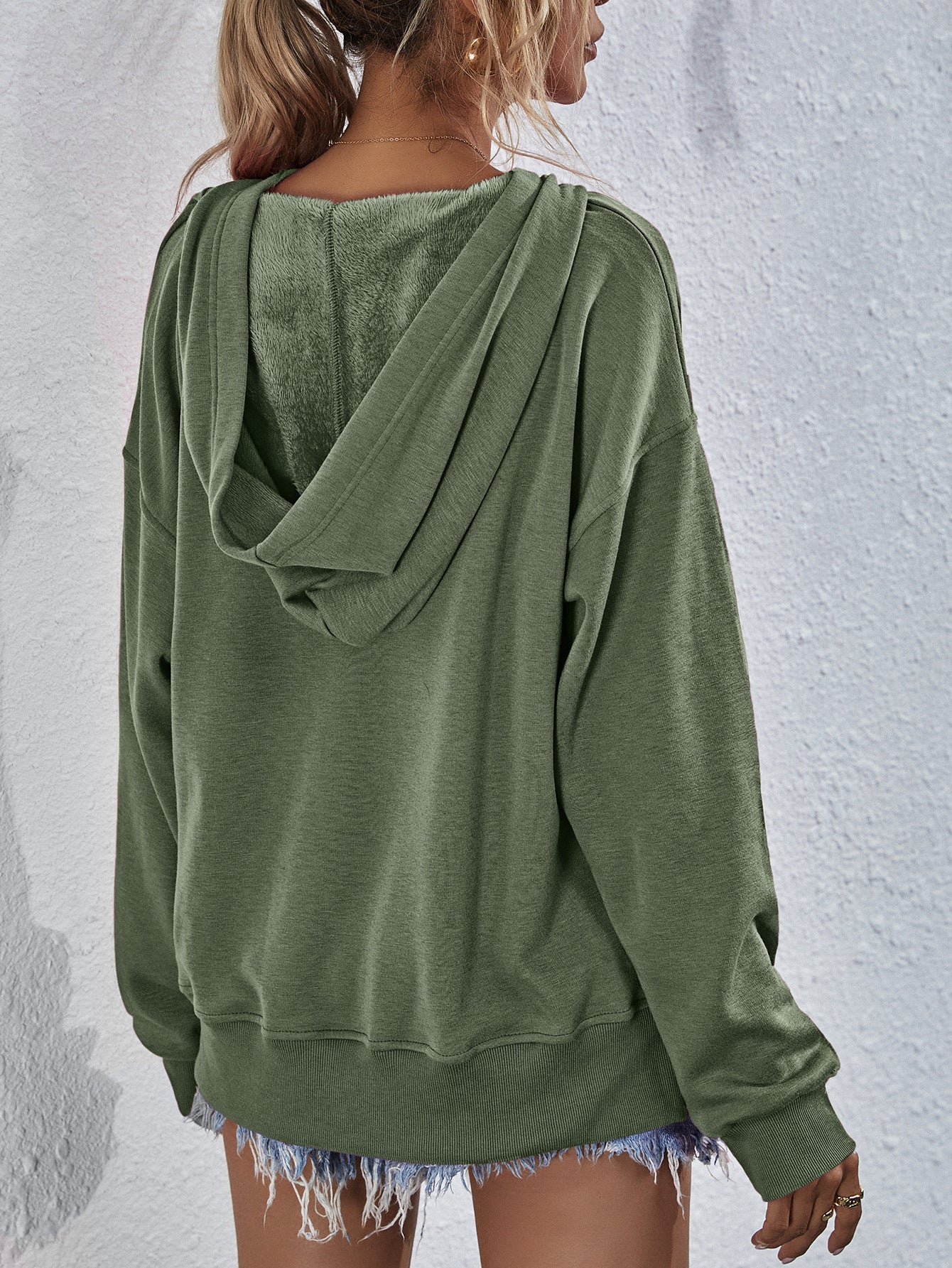 Moss green hooded sweatshirt with fuzzy lining and split hem detail.