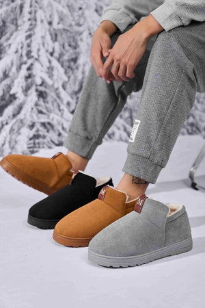 Suede shearling-lined house booties in caramel, black, and gray with slip-on style.