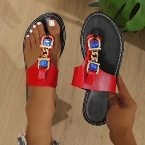 Red thong sandals with gold chain and blue rhinestone embellishments.