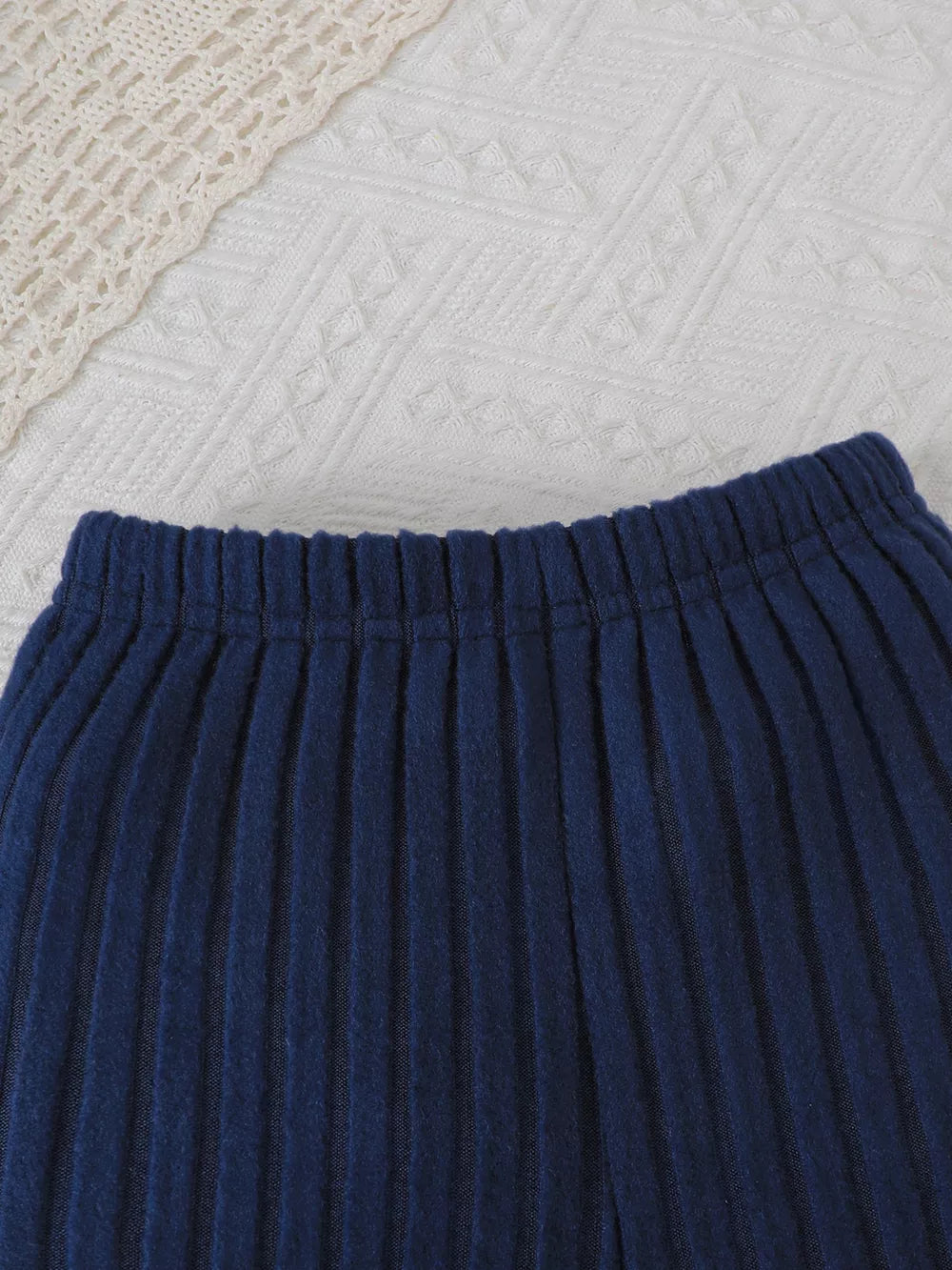 Navy ribbed knit toddler pants with elastic waistband and lace trim detail.