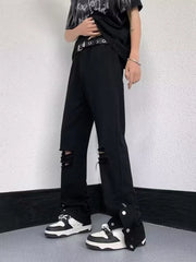 Black distressed loose-fit jeans with snap detail on the hem.