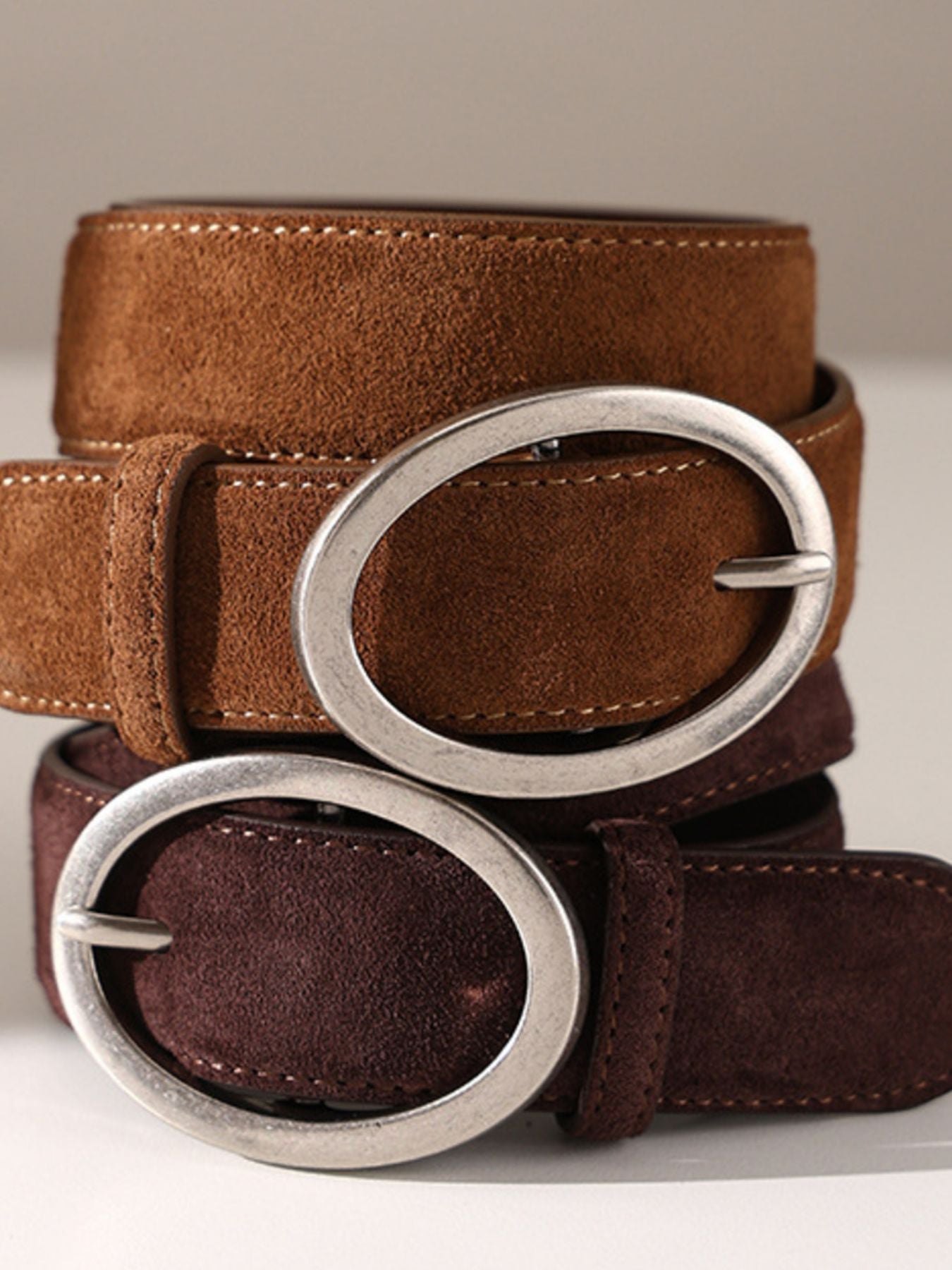 Brown and chocolate suede leather belts with oval brushed silver buckles