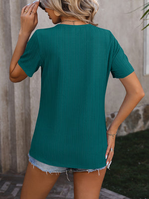Teal textured tee with short sleeves and a split hem, styled with denim shorts.