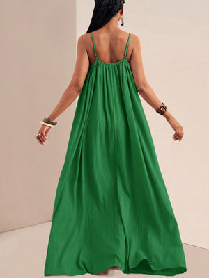Green maxi swim dress with spaghetti straps and gathered bodice, flowing skirt.