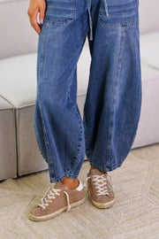 Balloon-leg denim jeans in medium wash with drawstring waist and pockets.