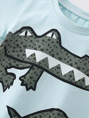 Light blue cotton toddler tee with a large green crocodile graphic and white teeth.