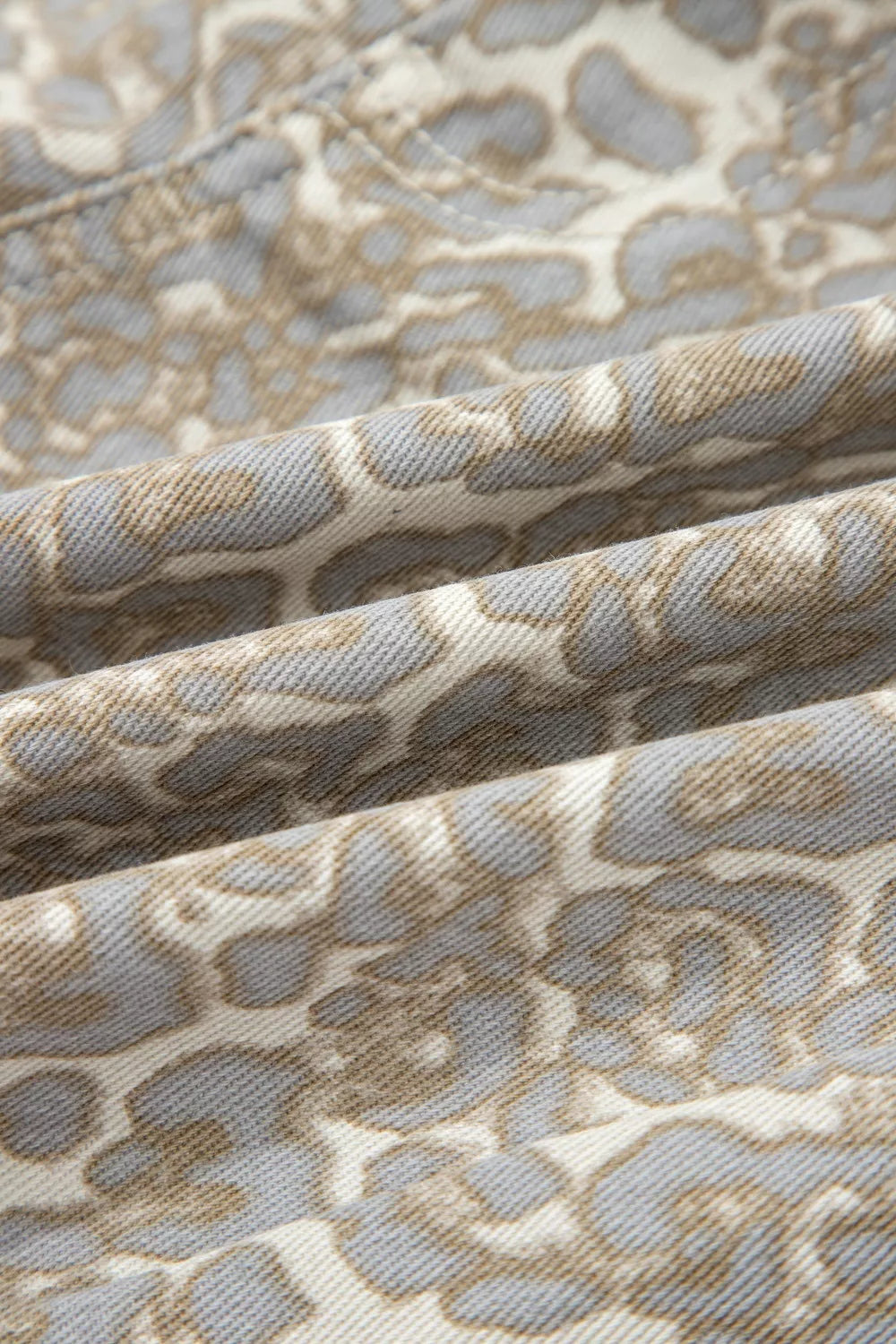 Denim shorts with a subtle grey and tan leopard print pattern.