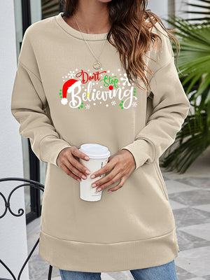 Beige crewneck sweatshirt with "Don't Stop Believing" holiday graphic and Santa hat detail.