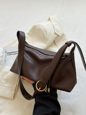 Soft slouchy crossbody bag in coffee color with adjustable strap and gold buckle detail.