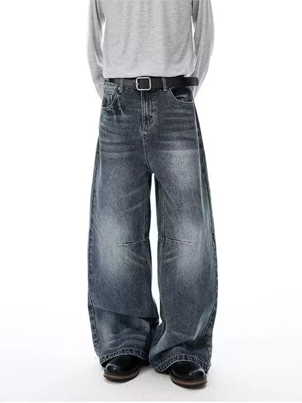 Men's vintage-inspired wide-leg jeans in washed denim with a black belt.