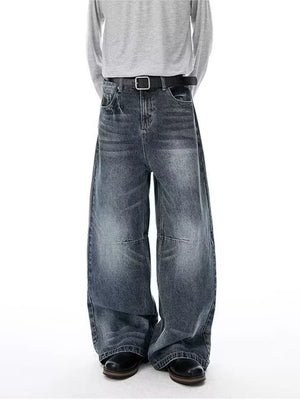 Men's vintage-inspired wide-leg jeans in washed denim with a black belt.