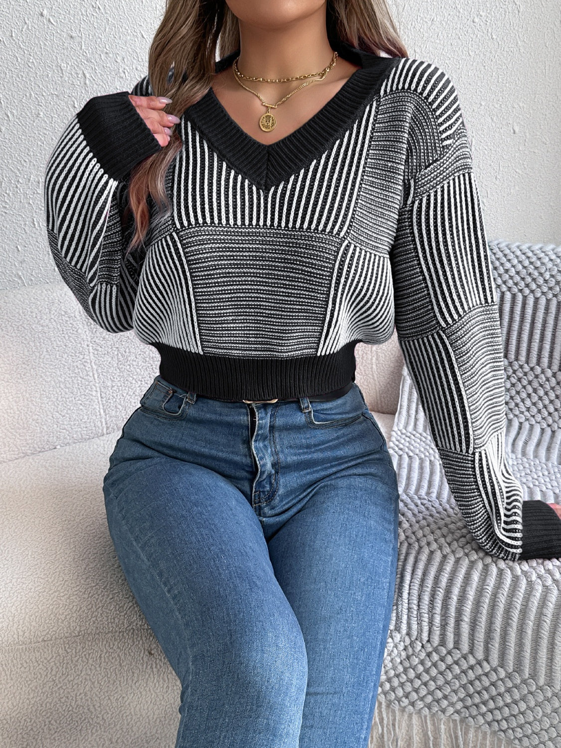 Black and white geometric stripe cropped V-neck knit sweater with ribbed cuffs and hem.
