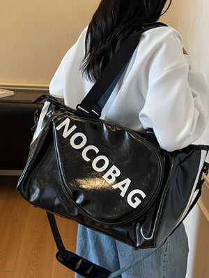 Black leather duffel bag with white logo and detachable strap.