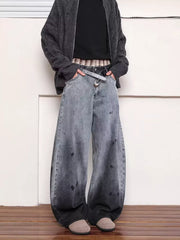 Men's washed wide leg jeans in faded grey with black splatters and distressed details.