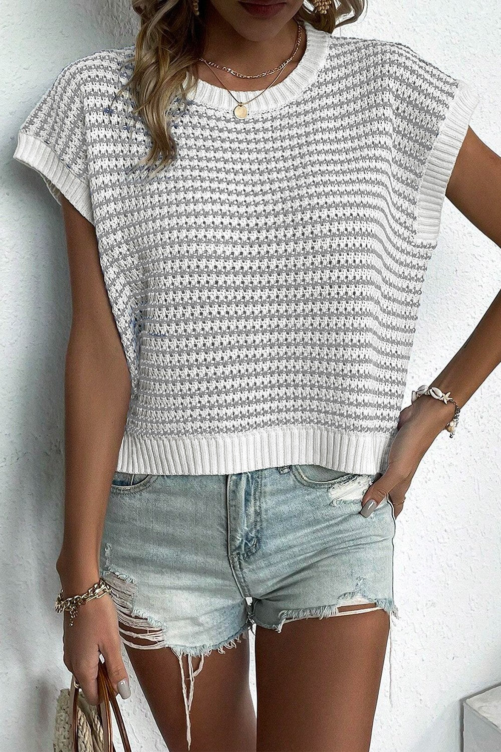 Sleeveless knit tank top with white and gray stripes, crew neck, and ribbed hem.