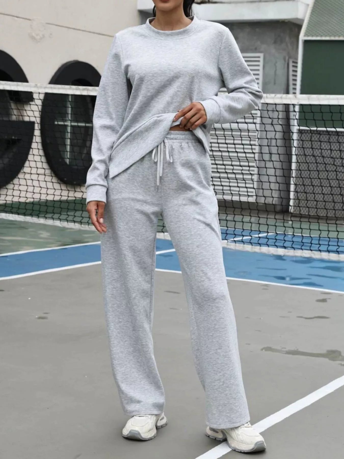 Light gray sweatpants with drawstring waist and wide leg, part of a two-piece set.