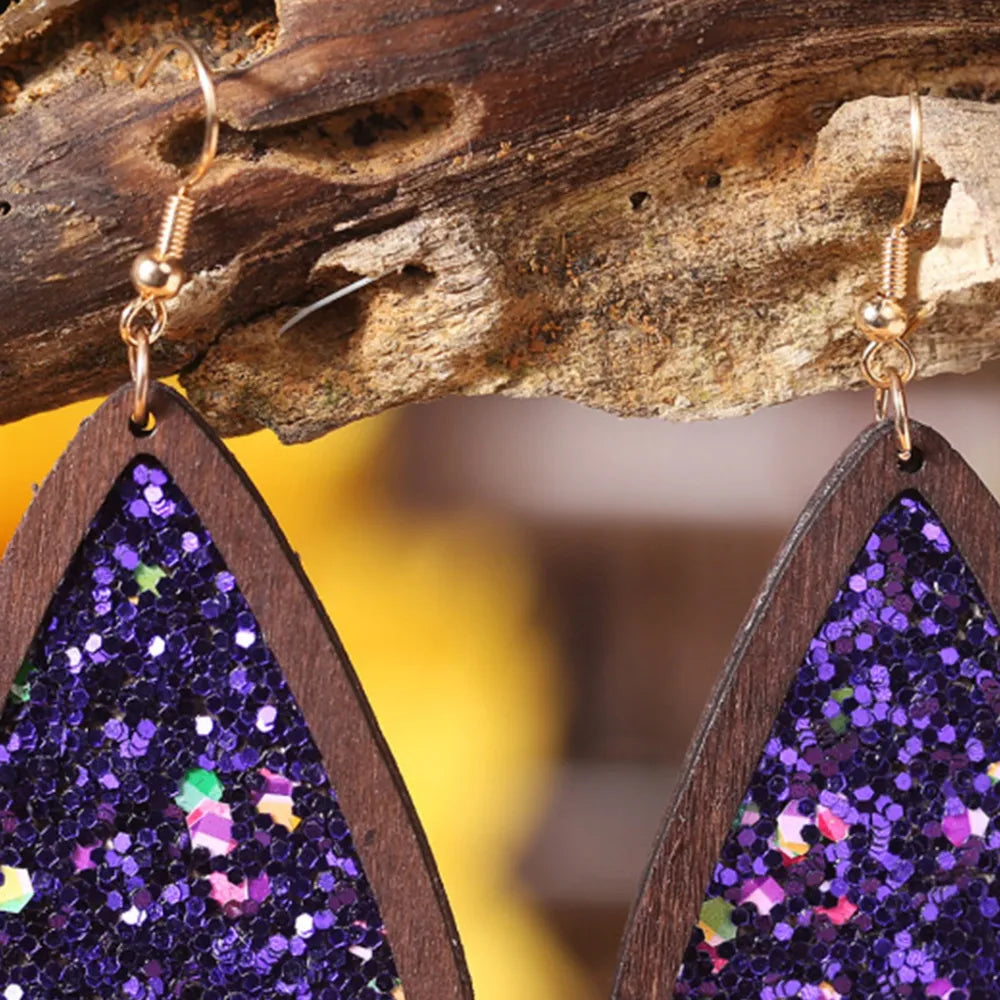 Wood-framed teardrop earrings with purple glitter inlay and gold hooks