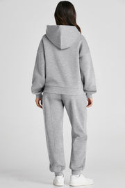 Gray relaxed fit loungewear set with seam detail on hoodie and pants.