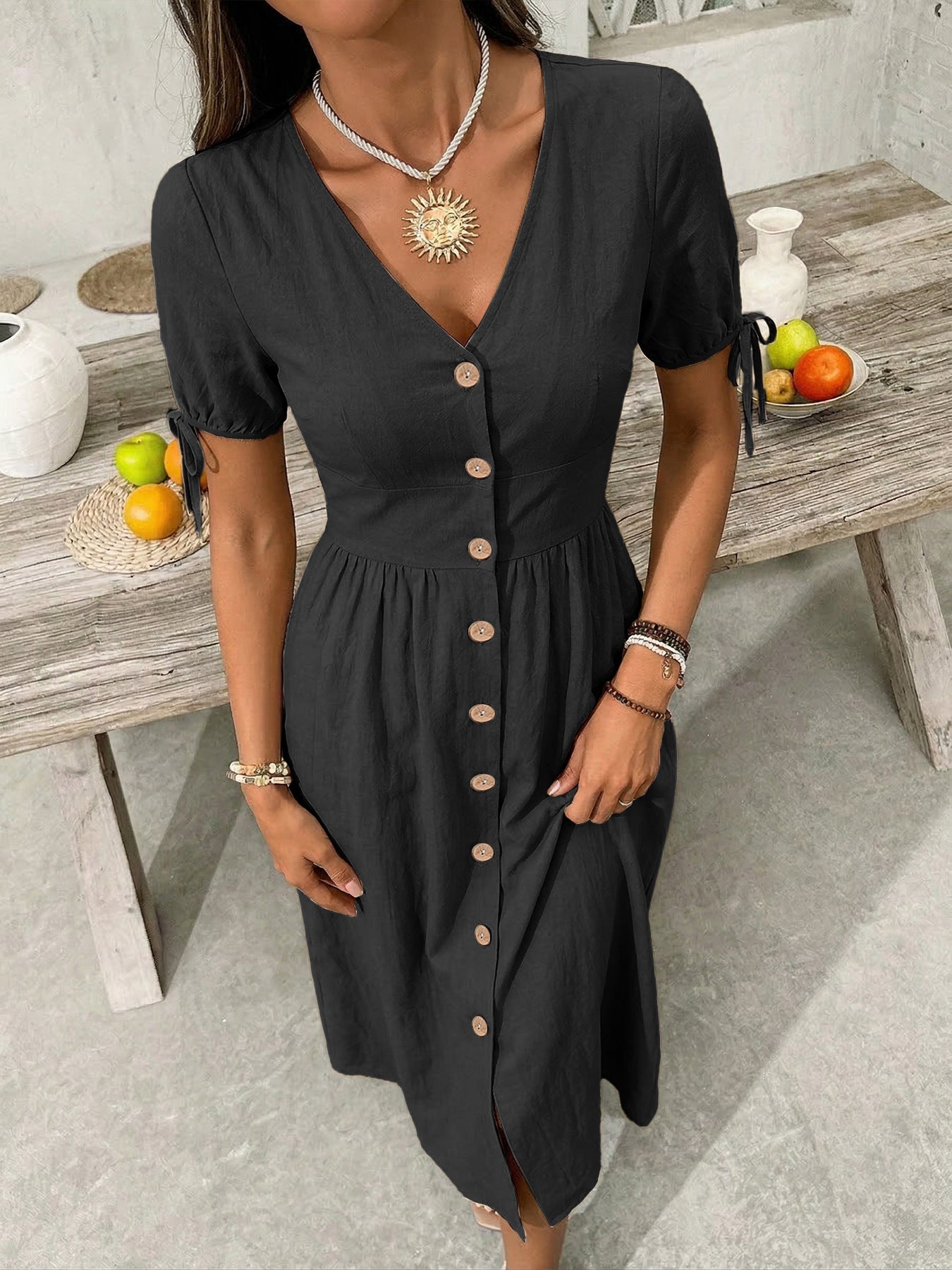 Black button-down midi dress with tie sleeve details and a V-neckline.