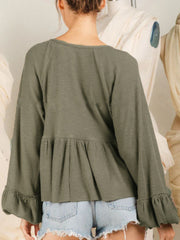 Textured ribbed peplum blouse in matcha green with ruffled cuffs and balloon sleeves.