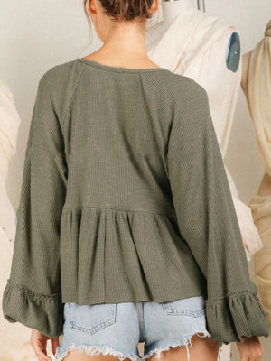Textured ribbed peplum blouse in matcha green with ruffled cuffs and balloon sleeves.