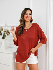 Rust knit sweater with boat neck, textured pattern, and slit hem detail.
