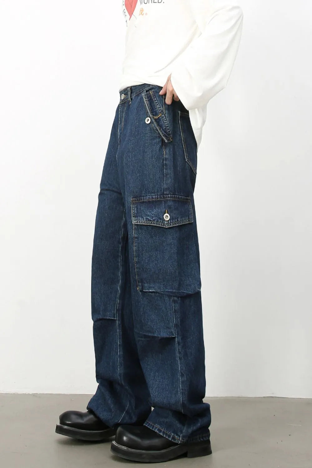 Denim palazzo cargo pants in dark wash with multiple pockets and a baggy fit.