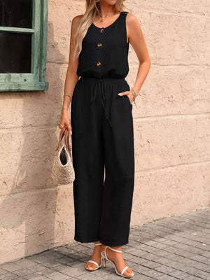 Black wide-leg romper with button detail, drawstring waist, and textured fabric.