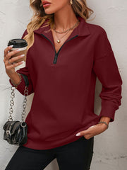 Burgundy quarter-zip sweatshirt with a relaxed fit and collared neckline.