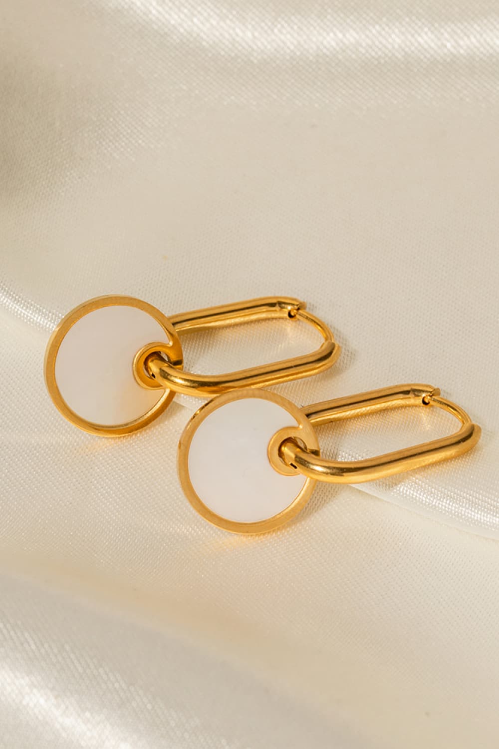 Gold mother-of-pearl disc drop earrings with oval links.
