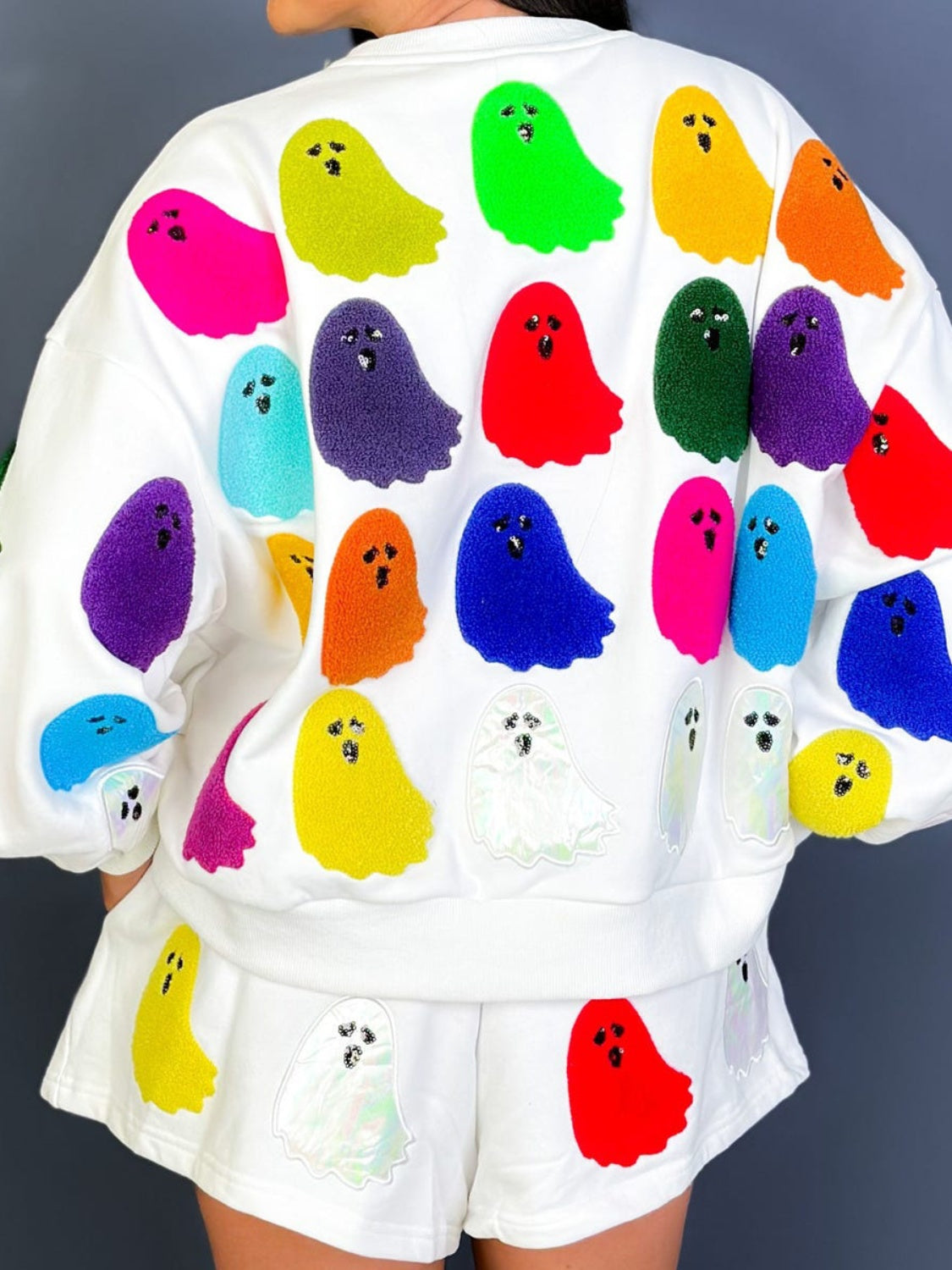 White loungewear set with multicolor ghost appliqués on sweatshirt and shorts.