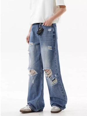 Men's distressed wide-leg jeans in light wash denim with ripped details.
