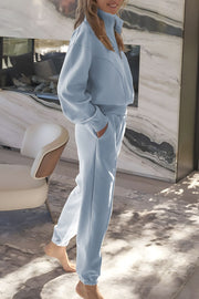 Light blue quarter-zip sweatshirt and jogger set with elastic cuffs and waistband.