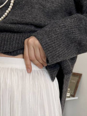 Flared sleeve ribbed turtleneck knit sweater in Floral Gray, styled with a white pleated skirt.