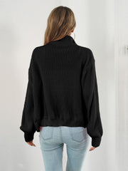 Black ribbed knit zip-up sweater with a mock neck and balloon sleeves.