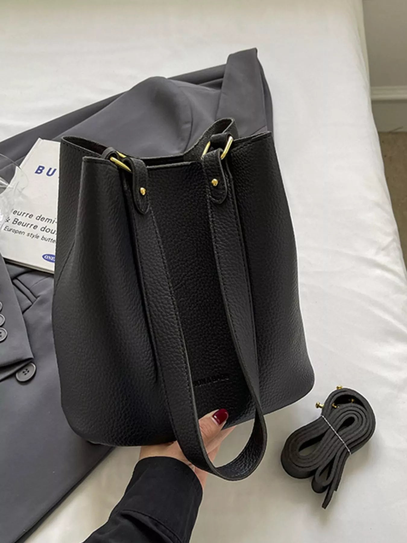 Black pebbled leather tote bag with gold hardware and adjustable strap