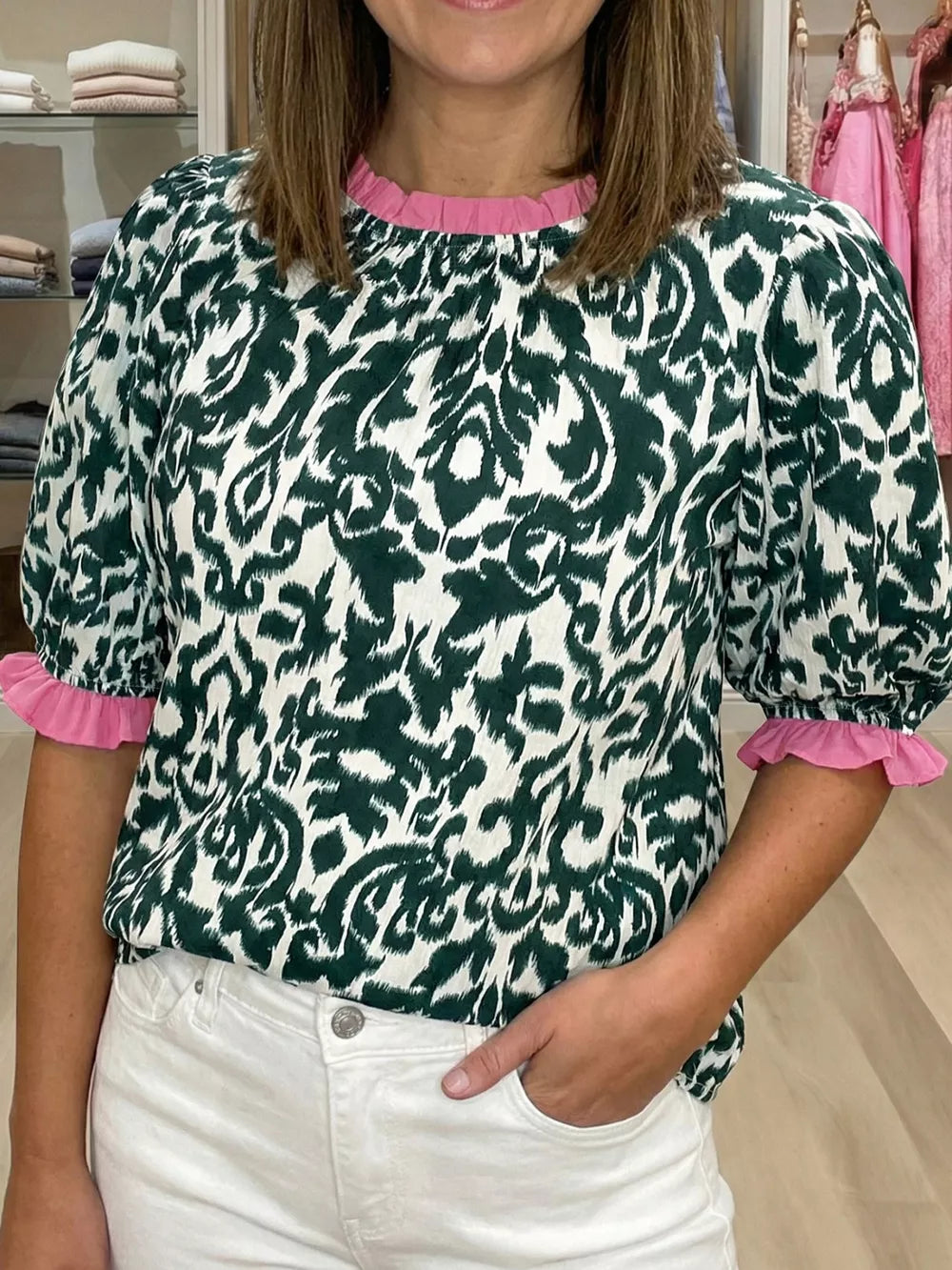 Green damask print maternity blouse with pink ruffled neckline and cuffs.