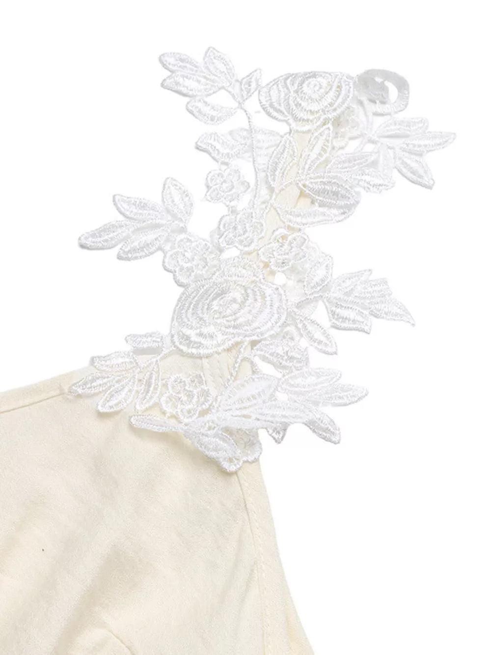 Beige maxi dress with white floral lace trim on the shoulder and V-neckline.
