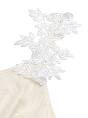 Beige maxi dress with white floral lace trim on the shoulder and V-neckline.