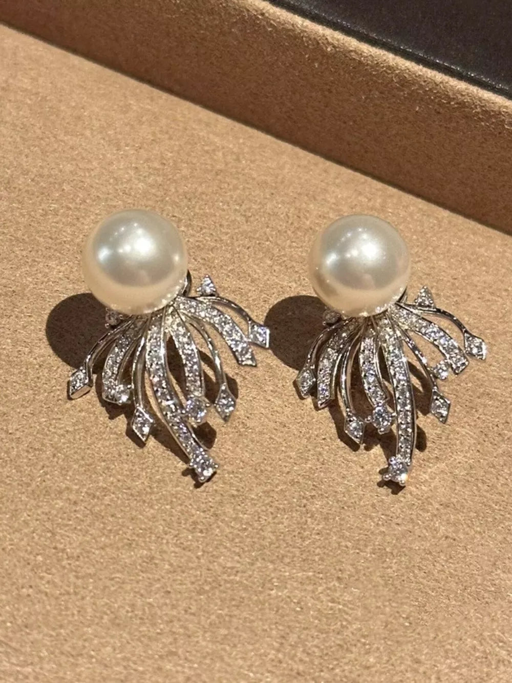 Luminous pearl and zircon silver earrings with intricate detailing.