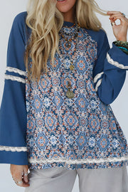 Bohemian print bell sleeve top in dusty blue with lace trim and ornate pattern.