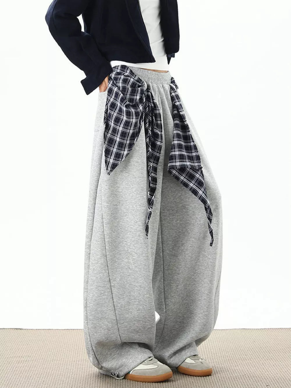 Relaxed fit grey sweatpants with wide legs and a plaid tie detail at the waist.