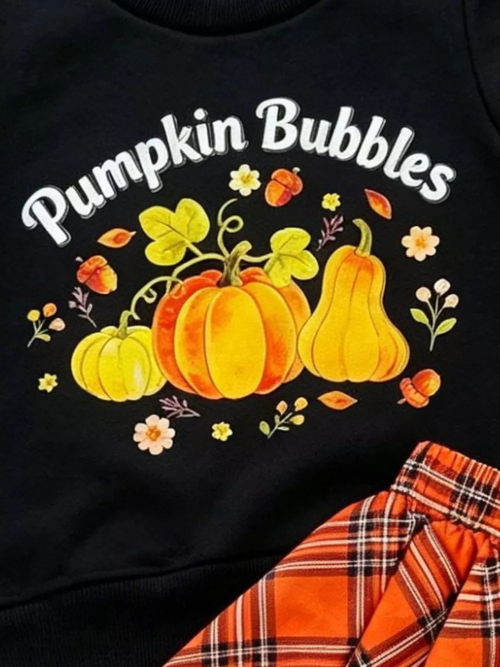 Black baby set with pumpkin print and orange plaid skirt.