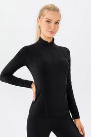 Black athleisure zip-neck top with seam details and long sleeves.